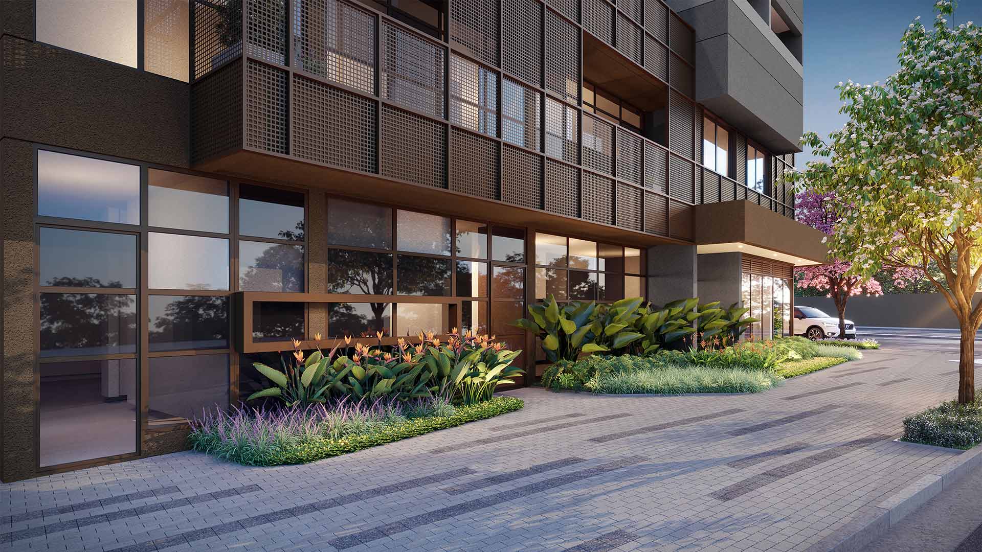 Detalhe da fachada térrea do edifício com paisagismo e calçada pavimentada